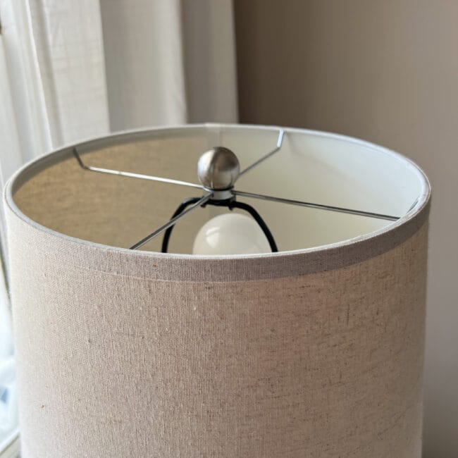photo of a round drum lampshade and it's arm fitter and finial