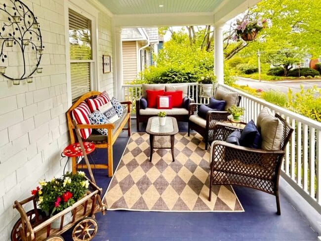 front porch with red, white and blue pillows and flowers