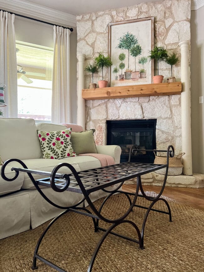 empty iron bench in front of white sofa with with stone fireplace.