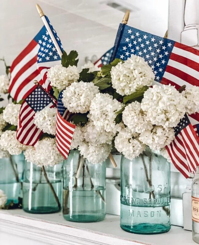 Lined up blue jars with white flowers and flags