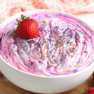 pink and purple dip with a strawberry on top in a white bowl