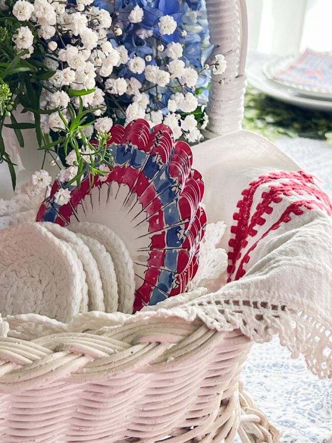 corner of a white basket with a vintage cloth and red white and blue coasters