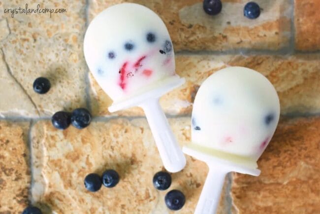 white popsicles with blueberries and raspberries inside