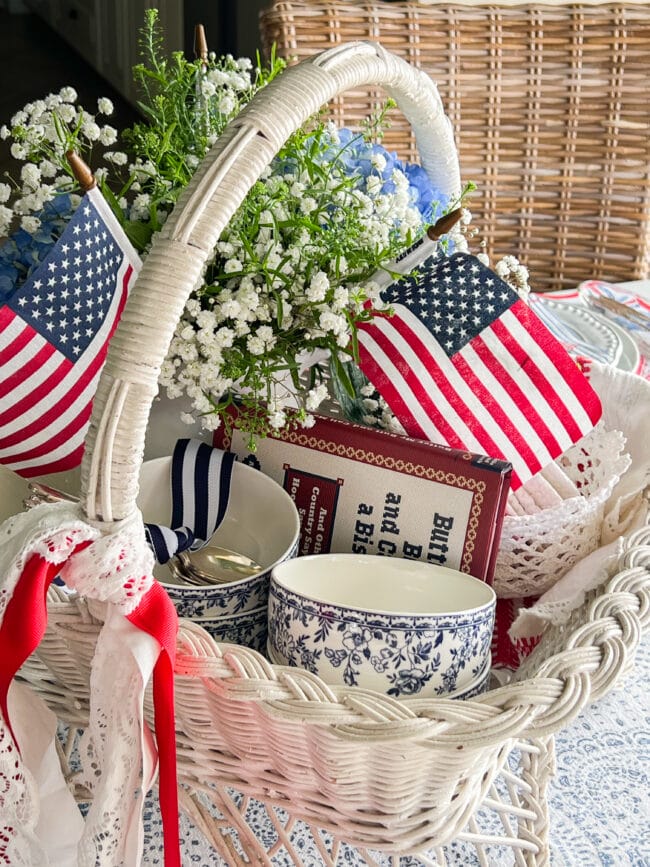 vintage basket with flags, blue and white bowls, a book and flowers