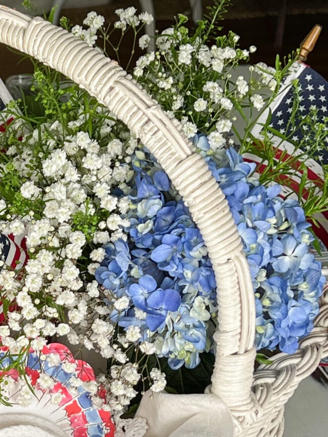 blue hydrangeas and white Baby's Breath flowers inside a white basket