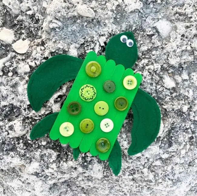green crafted turtle with buttons and popsicle sticks