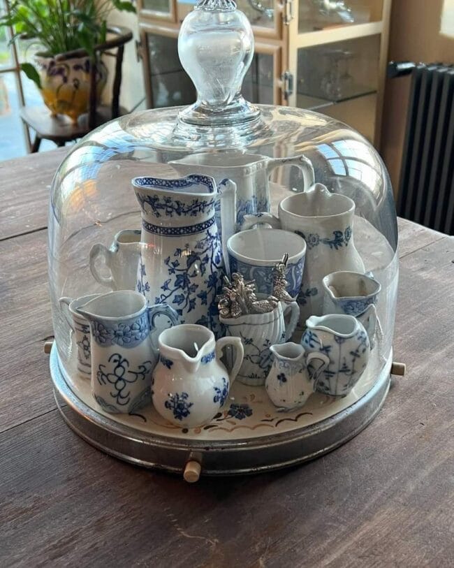 Cloche with blue and white mini dishes stacked inside.