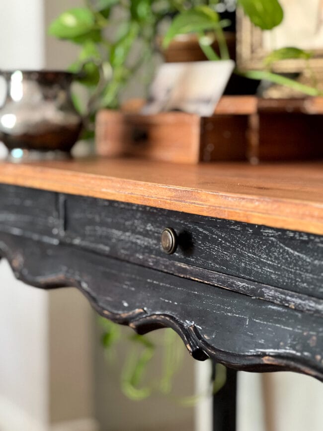 close up of the font of the black and wood table drawer and edges.