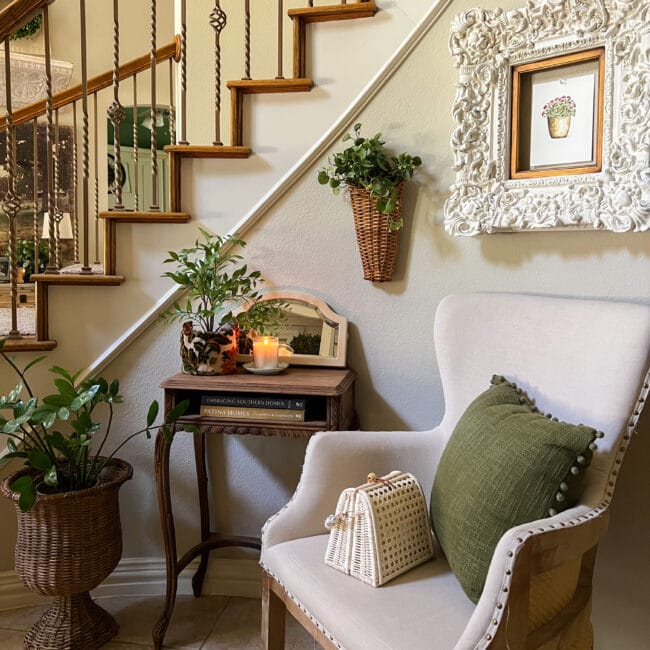 entryway seating with a chair, vintage wooden side table, wall art and plants