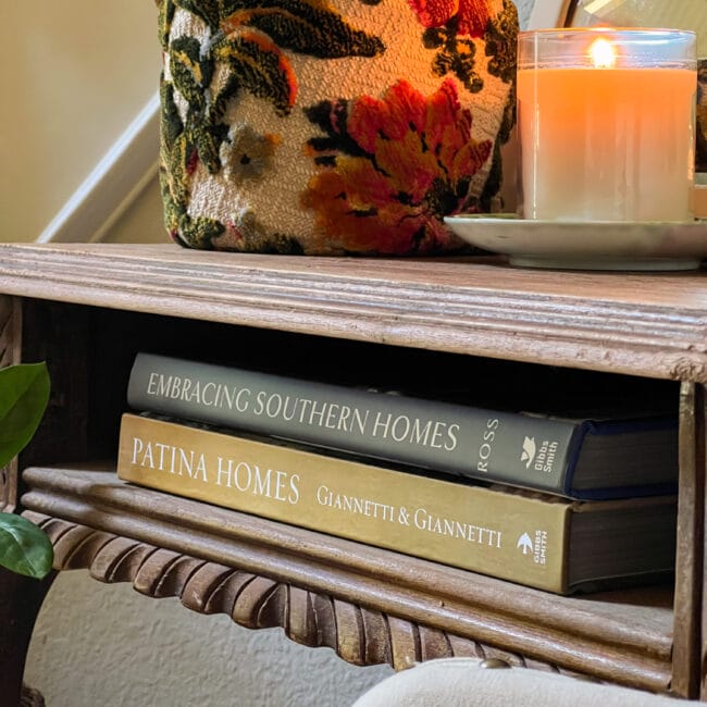 two home decorating books tucked inside a vintage wooden table