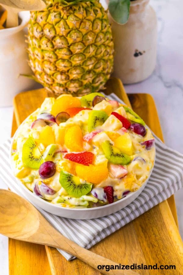 salad with kiwi, oranges, bananas, etc. in a white bowl