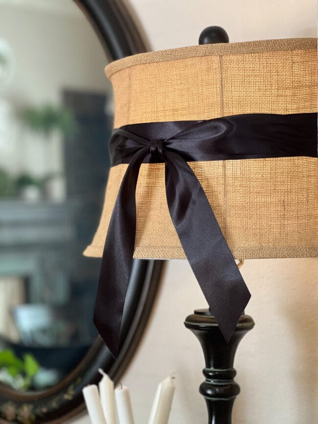 black satin ribbon tied around a burlap lampshade