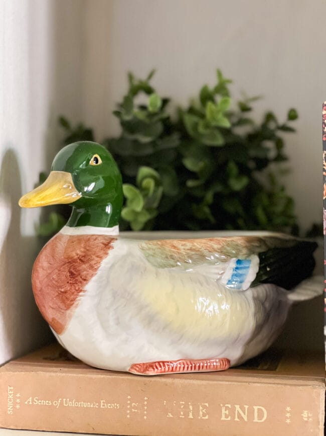 ceramic Mallard duck with faux plant behind it