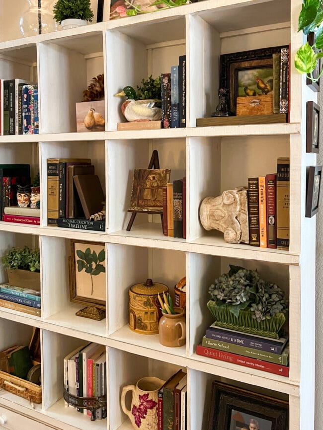 close up of cubbie shelf with fall colored books and vintage pieces