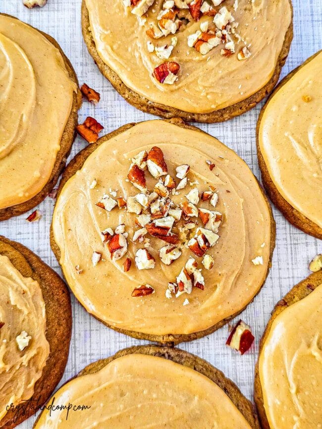 frosted brown sugar cookies with chopped pecans on top of icing