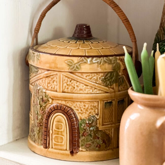 gold and brown vintage biscuit jar shaped like a round house with handle