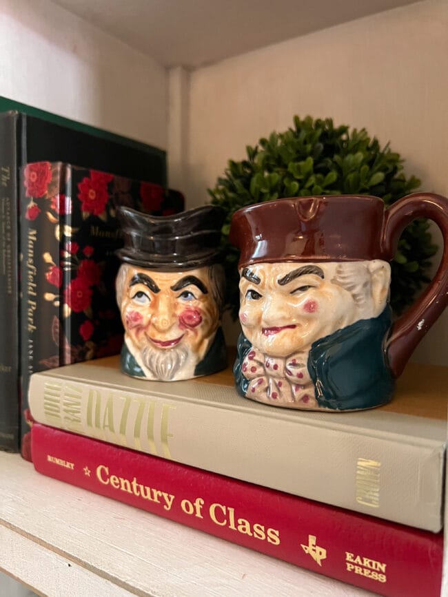 vintage cream and sugar bowl in the shape of men cranky faces sitting on books