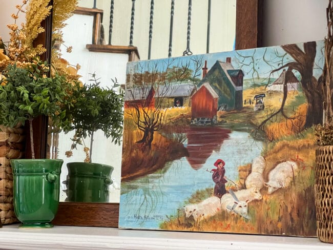 hand painted river scene with sheep and a house in background