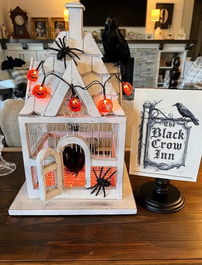 white birdcage with spiders and orange pumpkin light-up garland