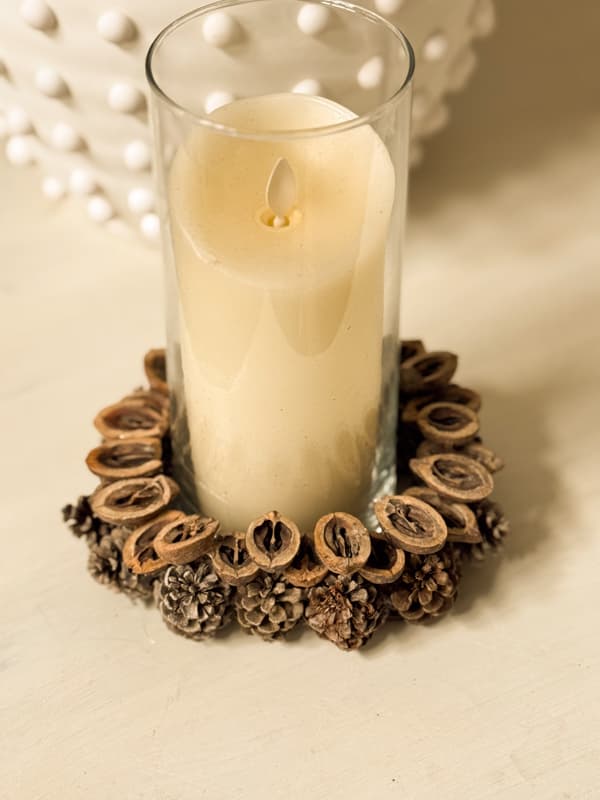 cream candle in glass jar with acorn ring around the bottom