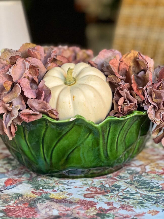 Green lettuce bowl with purple flowers and white pumpkins