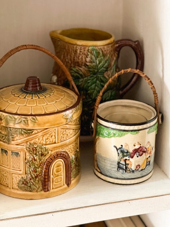 two biscuit jars with handles and a fall majolica pitcher in the background