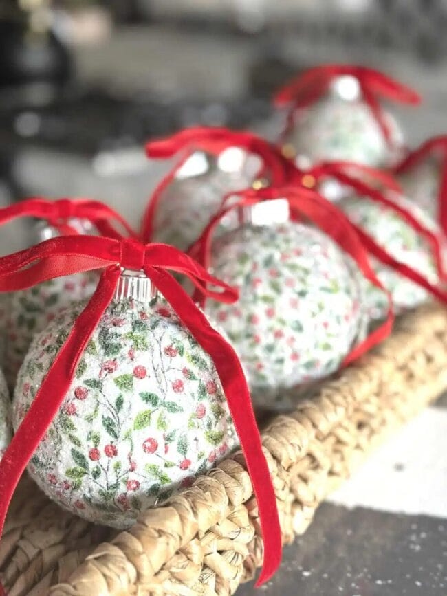 red ribbon tied around handmade ornaments sitting in a wicker tray