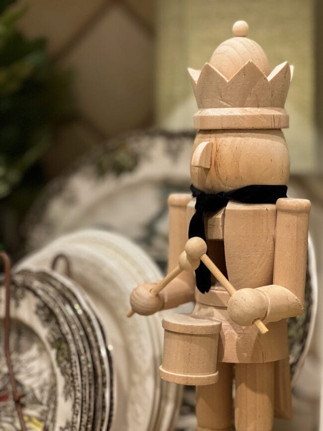 close up of natural wooden nutcracker with a black tie made from velvet ribbon