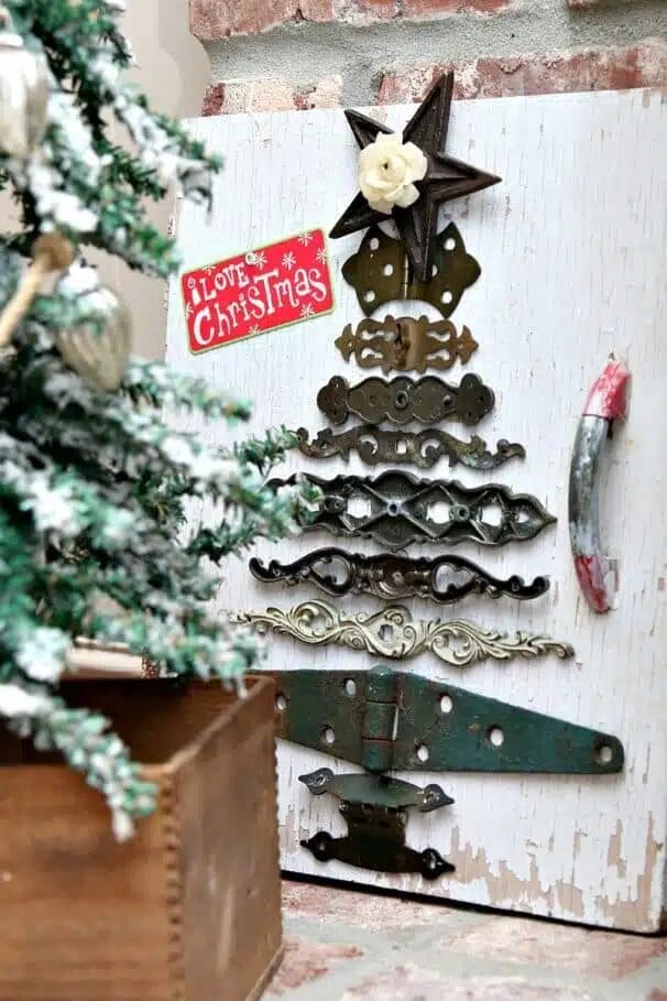 iron pieces stacked to make a christmas tree on a piece of wood