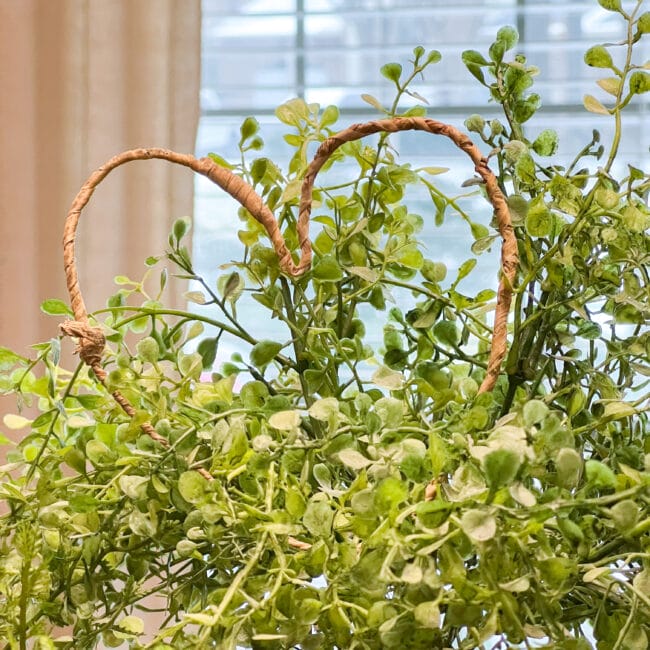 wire heart sitting on top of a faux topiary
