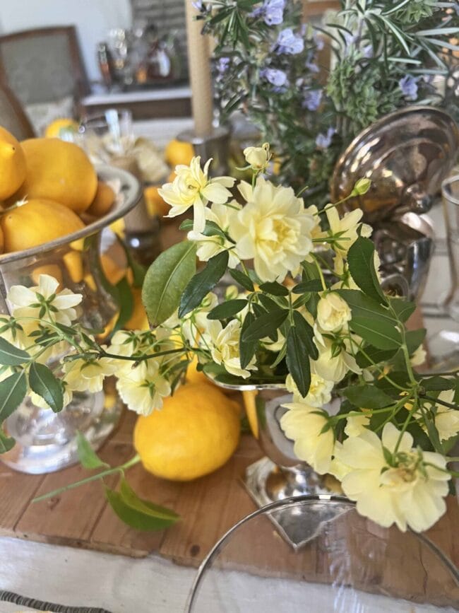 lemons on a tablescape with silver candlesticks and flowers