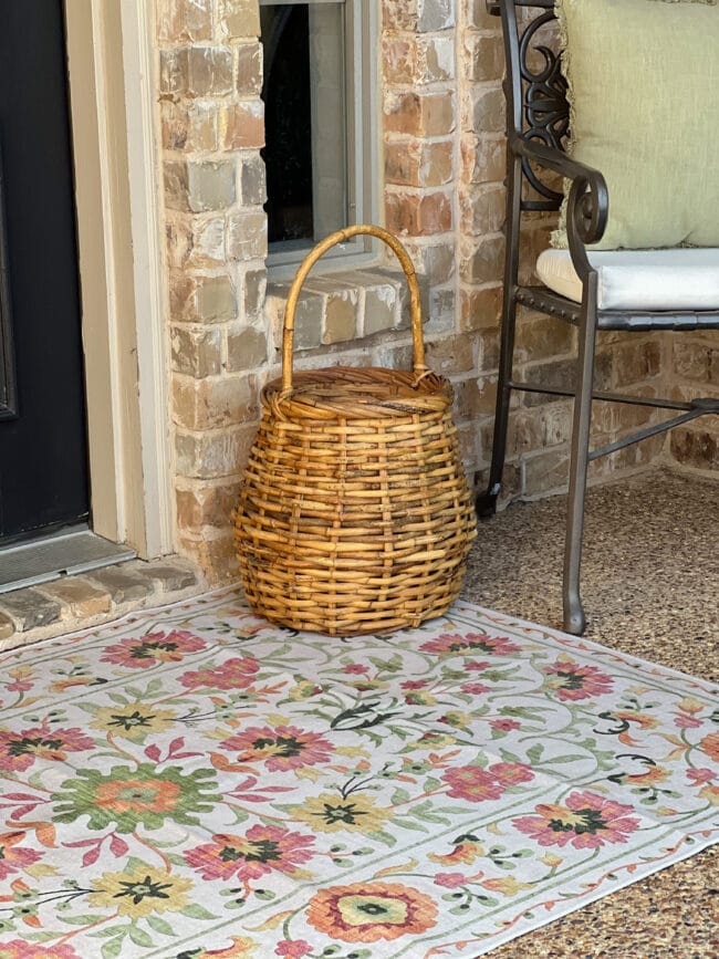 spring rug at front door with a vintage basket and iron chair