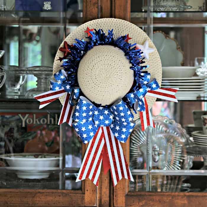 crafted patriotic hat hanging on the doors of a wooden china cabinet