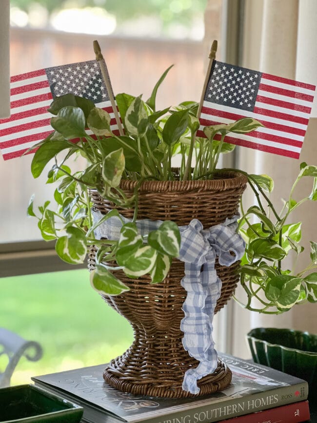 brown wicker urn with plant and flags inside