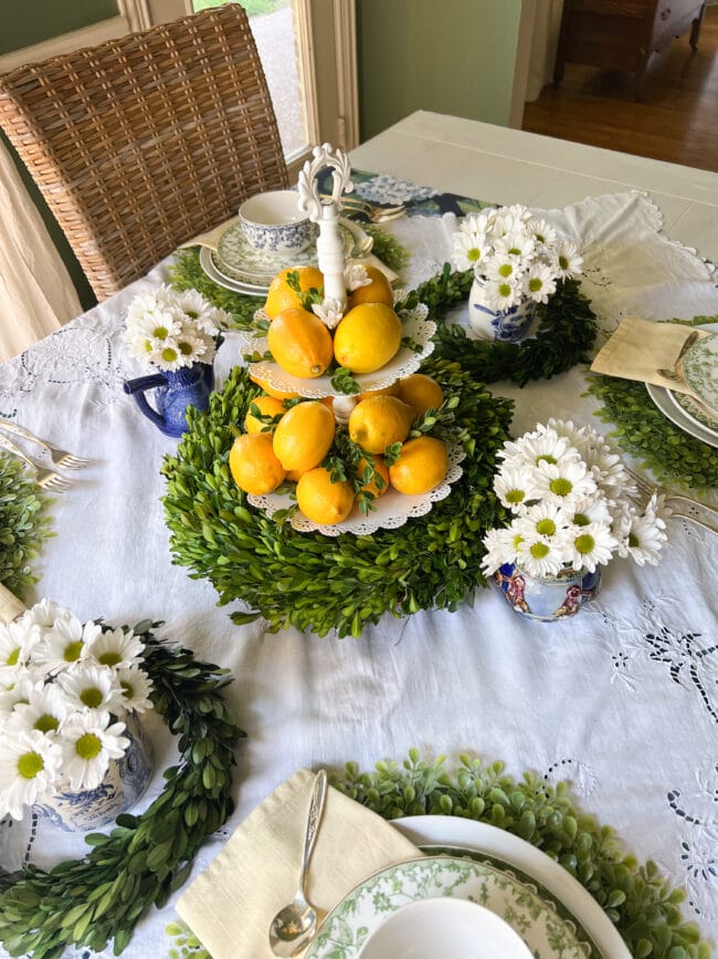 Full photo of the centerpieces of lemon tiered tray and small vintage pots with daisies and wreaths