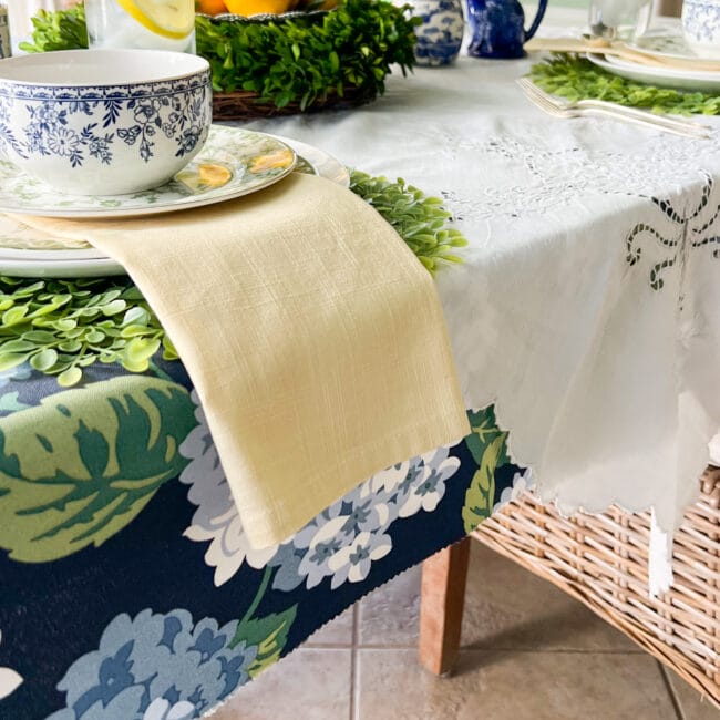 place setting with dual tablecloths and a yellow napkin