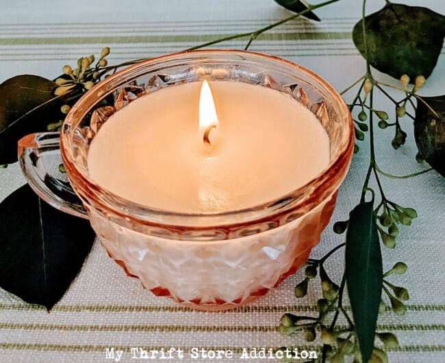 handmade candle poured into a vintage pink depressions glass teacup