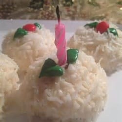 snowball desserts with a pink candle and green leaves on top