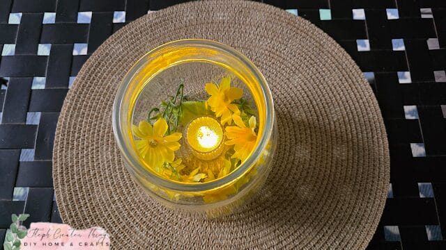 clear vase candle holder with yellow flowers inside