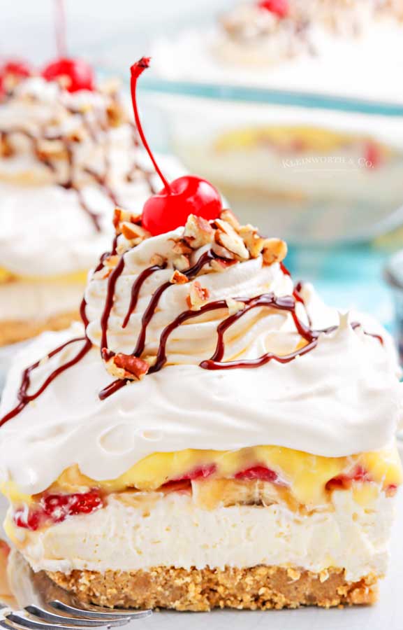 piece of Banana split cake with a cherry and nuts on top