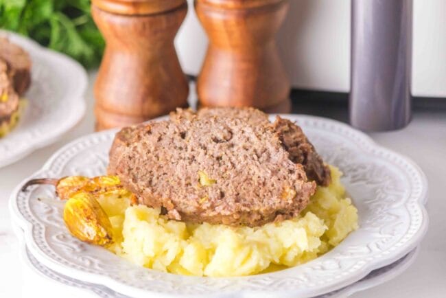 slice of meatloaf on a bed of mashed potatoes