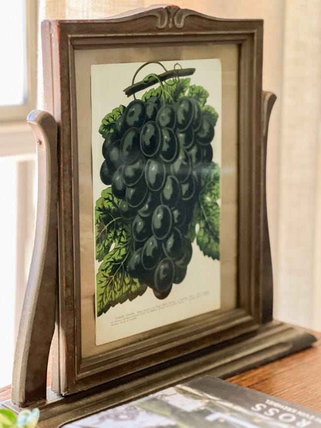 Antique cheval tabletop mirror with an image of dark grapes 