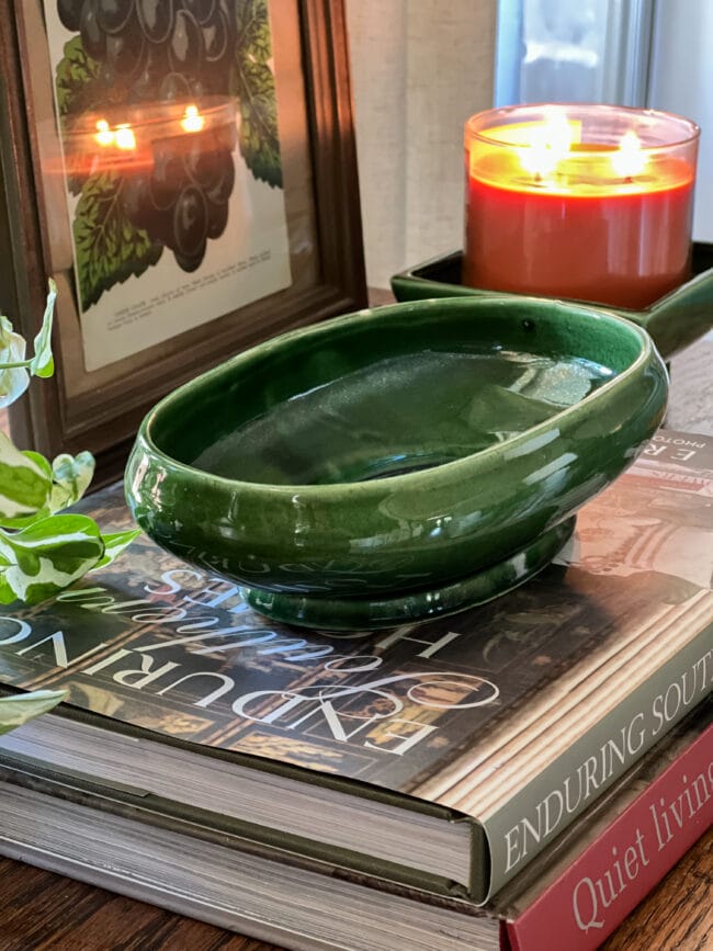 coffee table books with a vintage green oblong bowl sitting on top of them