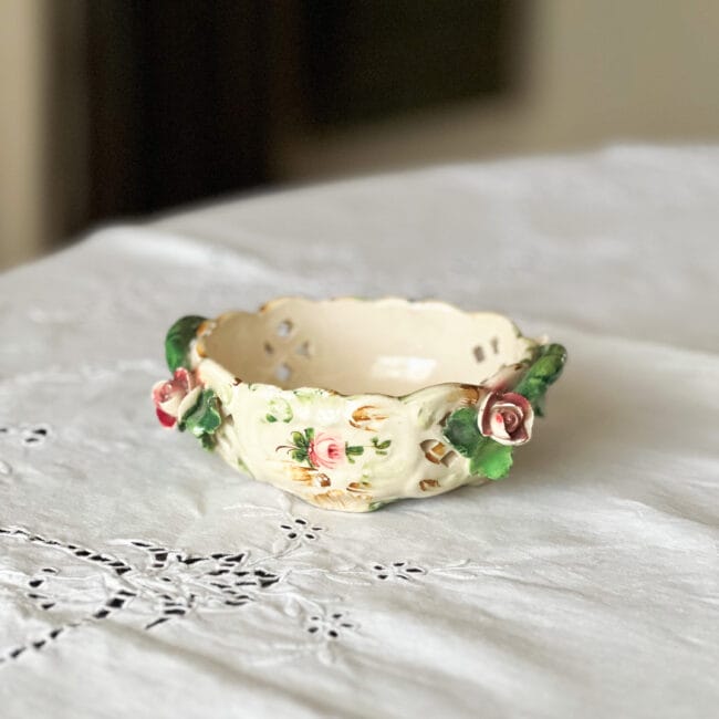 small vintage bowl with rose handles on a white tablecloth