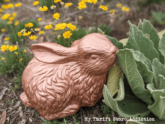 bronze painted ceramic bunny in a garden
