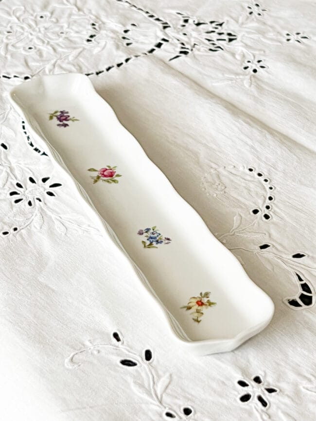 Vintage white olive holder with flowers on a white tablecloth