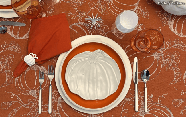 rust colored place setting with pumpkins plates, napkin rigs and goblets