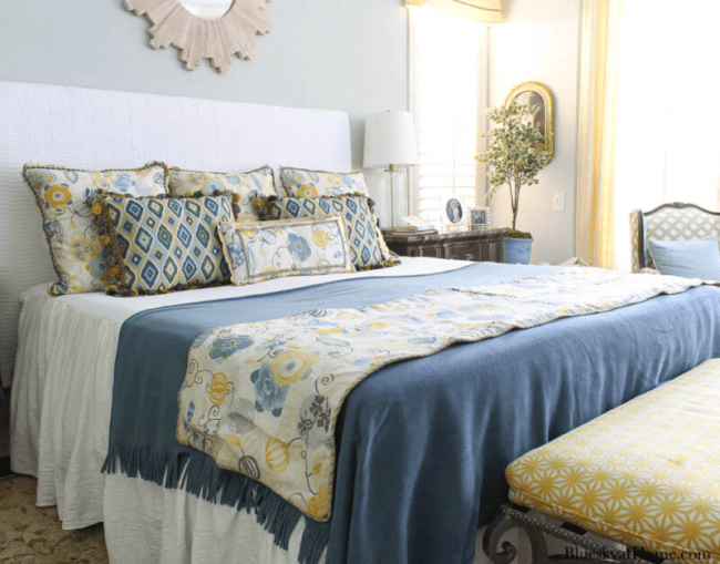 Bed with blue and gold bedding and pillows on the bed