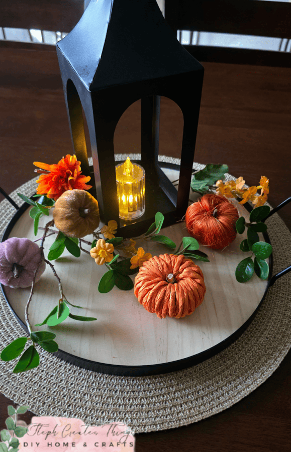 tray with black lantern, pumpkins, a candle and vines